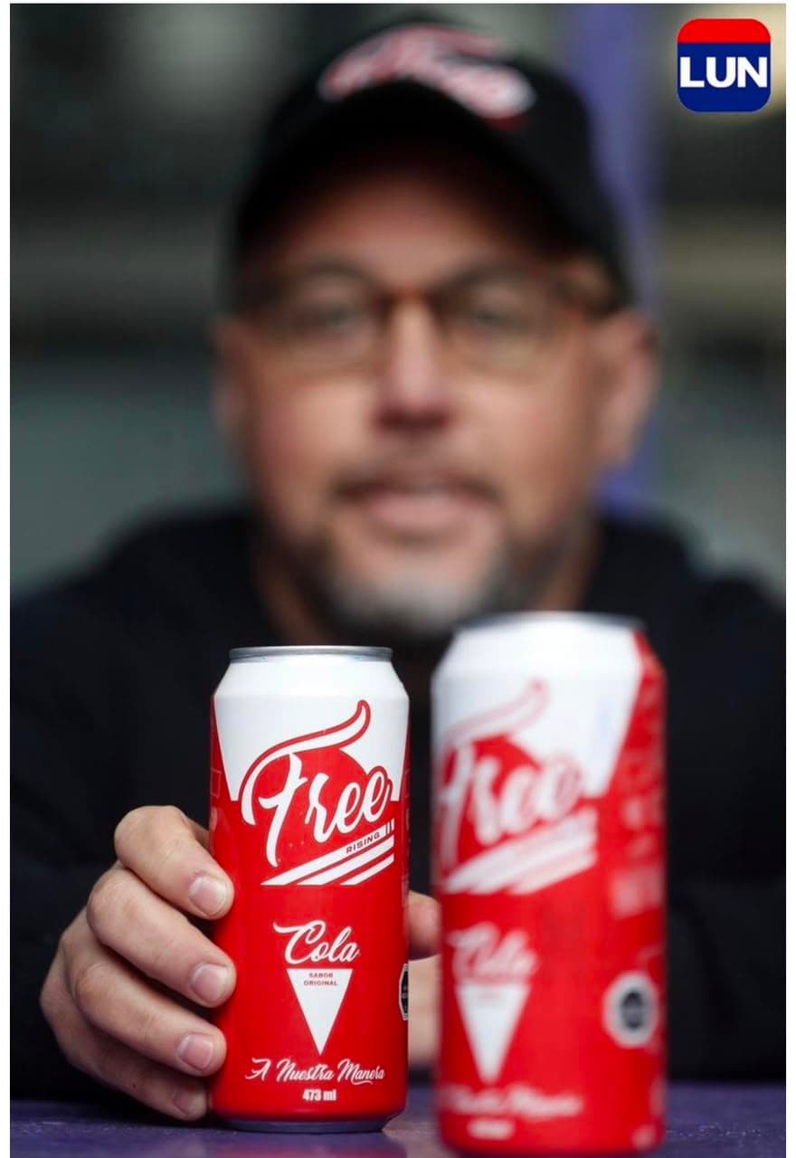 Juan Carlos Navarrete sostiene dos latas de Free Rising Cola, fotografía de Rubén García publicada en Las Últimas Noticias